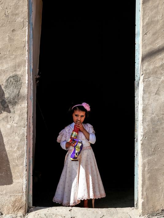 Houra berada di rumahnya di desa Wahed Haziran, Provinsi Diwaniya, Irak, (17/3). Keterbatasan ekonomi membuat bocah empat tahun ini tak bisa menjalani perawatan. (AFP Photo/Haidar Hamdani)