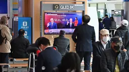 Orang-orang menonton program berita televisi tentang pemilihan presiden (pilpres) AS yang menampilkan gambar Presiden Donald Trump (kiri) dan calon presiden dari Partai Demokrat Joe Biden (kanan), di sebuah stasiun kereta api di Seoul, Korea Selatan pada Rabu (4/11/2020). (Photo by Jung Yeon-je/AFP)