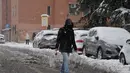 Seorang pria berjalan di tengah salju di Milan, Italia utara (28/12/2020). Hujan salju mengguyur Milan pada Senin (28/12). (Xinhua/Daniele Mascolo)