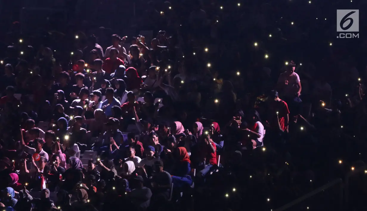 Ribuan penonton menyalakan flash ligt di ponselnya masing-masing saat malam penutupan Asian Games 2018 di Stadion GBK, Jakarta, Minggu (9/2). Hal ini menjadi unik dan menambah syahdu malam penutupan Asian Games 2018. (Liputan6.com/Helmi Fithriansyah)