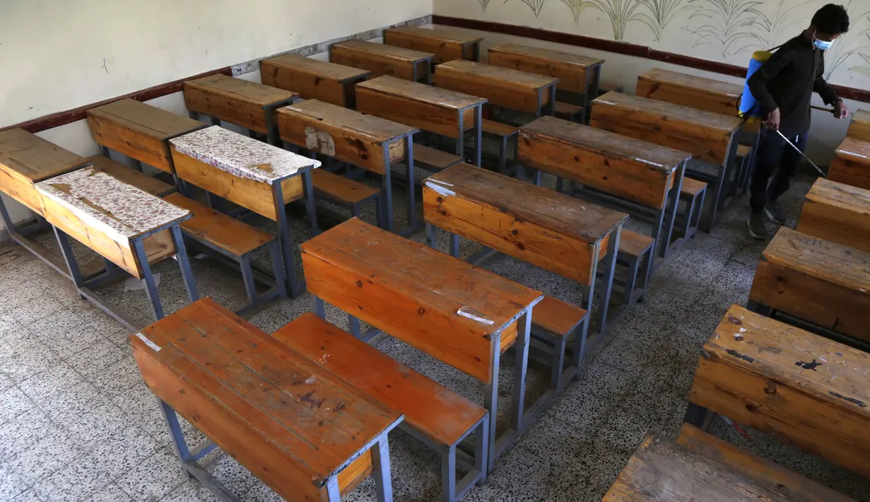 Seorang petugas kesehatan mendisinfeksi sebuah ruang kelas sebelum para siswa datang untuk mengikuti ujian di sebuah sekolah di Sanaa, Yaman (30/8/2020). (Xinhua/Mohammed Mohammed)
