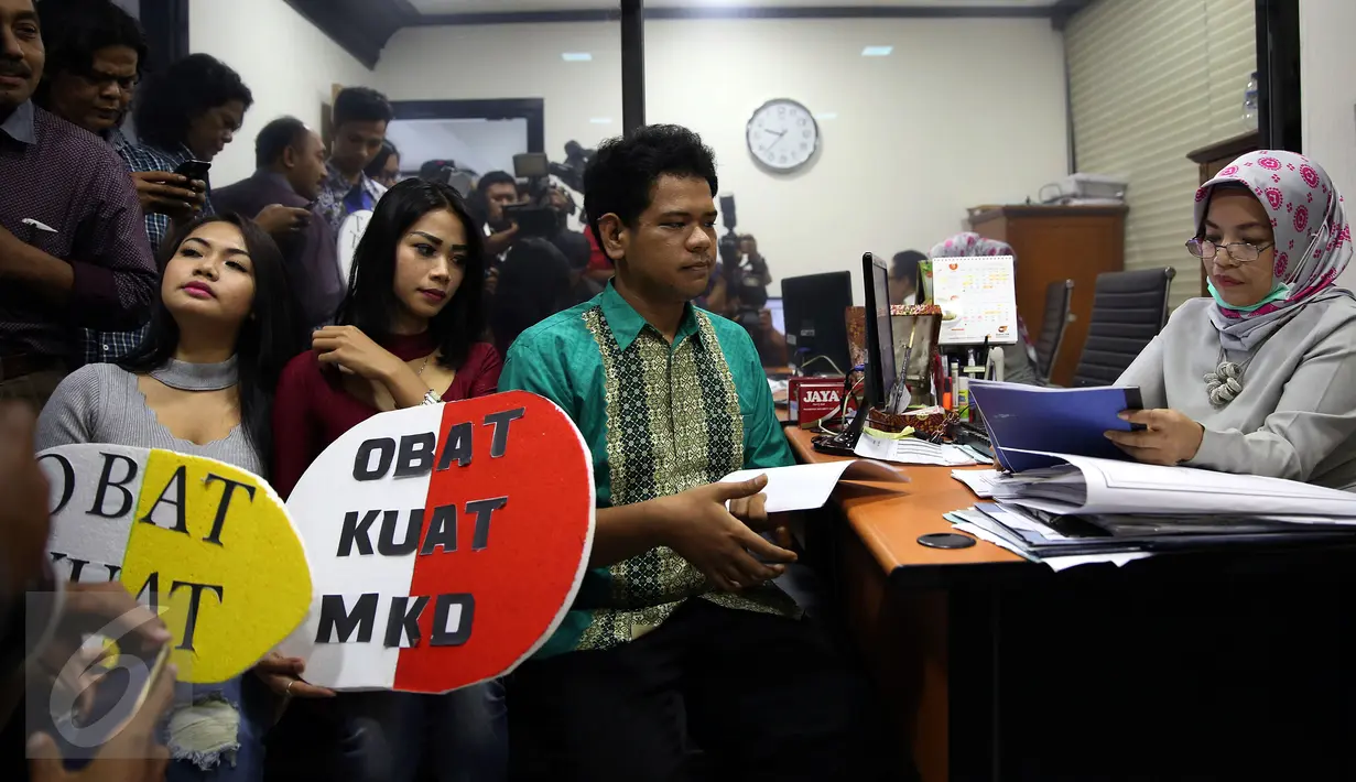 Pegawai MKD menerima dokumen laporan dan simbolik obat kuat yang diberikan oleh sejumlah orangdari Indonesia Parlemen Watch (IP Watch) di Kompleks Parlemen, Jakarta, Kamis (24/11). (Liputan6.com/Johan Tallo)