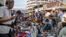 Sebagai informasi, cakupan Sensus Ekonomi 2026 adalah seluruh usaha ekonomi, termasuk usaha mikro/rumah tangga (pedagang pasar, warung, usaha online, industri tekstil, jasa, dll), kecuali sektor pertanian. Tampak dalam foto, orang-orang melihat-lihat barang bekas di salah satu ruas jalan, Surabaya, Jawa Timur, pada Minggu 19 April 2026. (JUNI KRISWANTO/AFP)