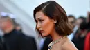Model Bella Hadid berpose untuk fotografer di karpet merah pembukaan Festival Film Cannes 2017 di Prancis, Rabu (17/5). Penampilan Bella Hadid dilengkapi dengan kalung berbandul batu safir biru yang tampak mewah. (AFP PHOTO / Alberto PIZZOLI)