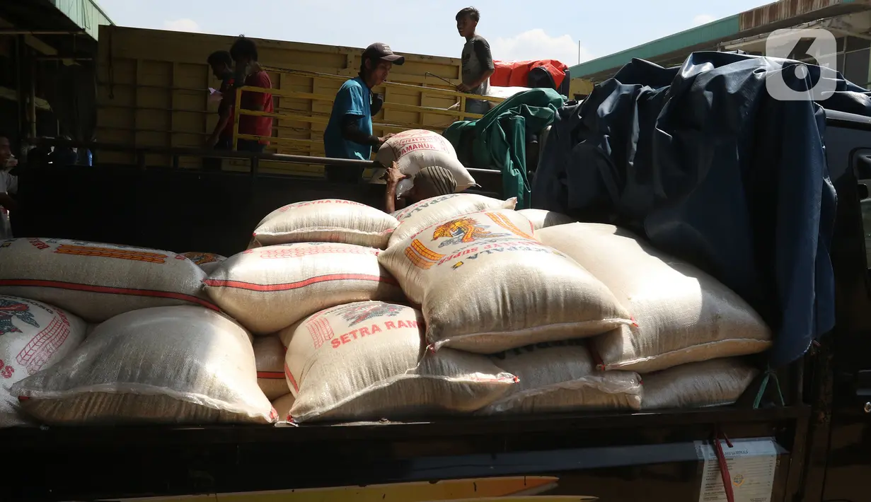 Buruh memenidahkan karung beras di pasar induk beras Cipinang, Jakarta, Sabtu (16/5/2020).  mengantisipasi penyebaran Covid-19 sejumlah kuli dan buruh di Pasar Induk beras Cipinang diberi obat herbal mentah untuk meredakan panas. (Liputan6.com/Herman Zakharia)