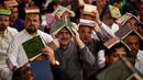 <p>Para pria Syiah menaruh mushaf Alquran di atas kepala mereka saat menghadiri sholat lailatulqadar pada bulan suci Ramadhan. (AP Photo/Anmar Khalil)</p>