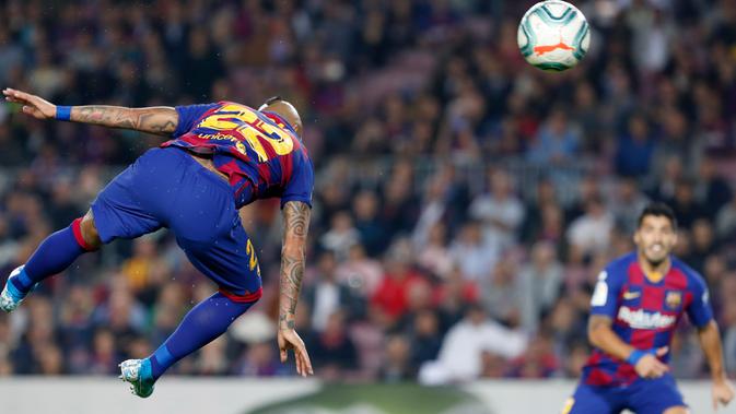 Gelandang Barcelona, Arturo Vidal menyundul bola saat menjamu Real Valladolid dalam pertandingan pekan ke-11 La Liga di Camp Nou, Selasa (29/10/2019). Barcelona sukses merebut puncak klasemen La Liga pekan ini setelah menang telak dengan skor 5-1 atas Valladolid. (AP/Joan Monfort)