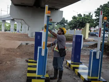 Pekerja mengecek pintu parkir di lahan yang dijadikan park and ride untuk stasiun MRT (Moda Raya Terpadu) Lebak Bulus, Jakarta, Selasa (20/3). Dua stasiun MRT dilengkapi dengan park and ride untuk fasilitas penumpang. (Liputan6.com/Faizal Fanani)