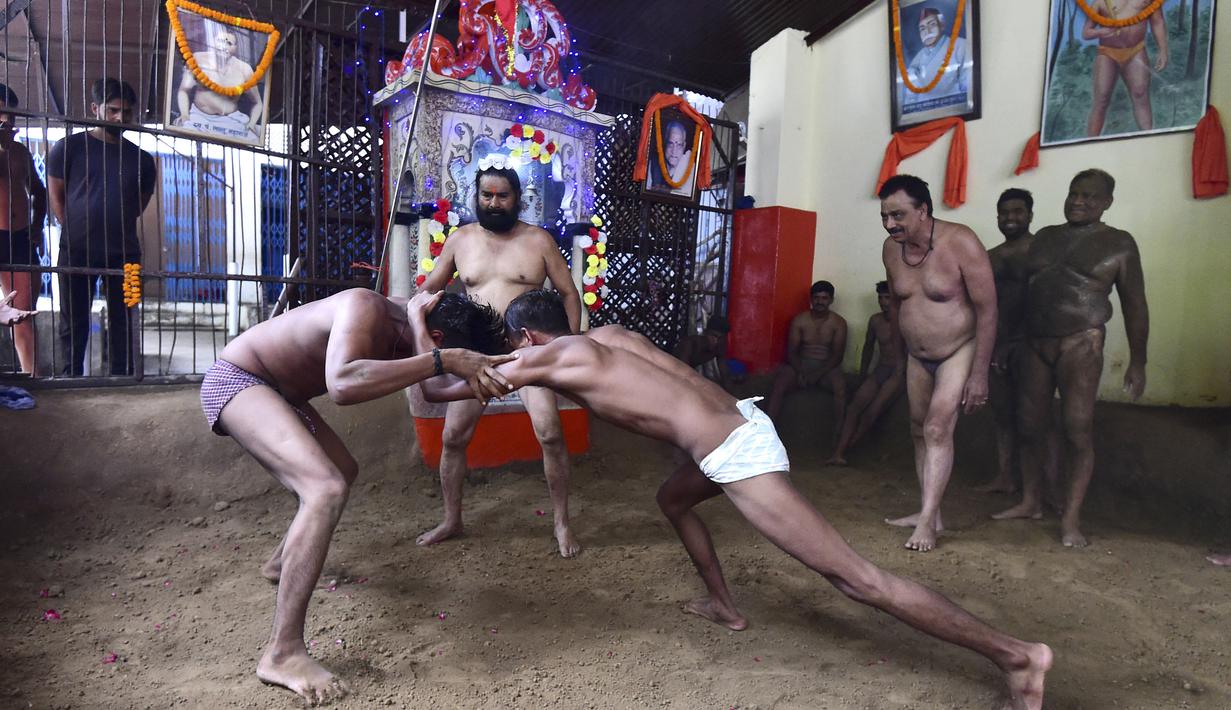 Pegulat beraksi dalam pertandingan gulat tradisional di klub gulat Loknath Vyayamsala di Prayagraj, India, (21/8/2023). Acara tersebut untuk merayakan festival Hindu Nag Panchami. (AFP/Sanjay kanojia)