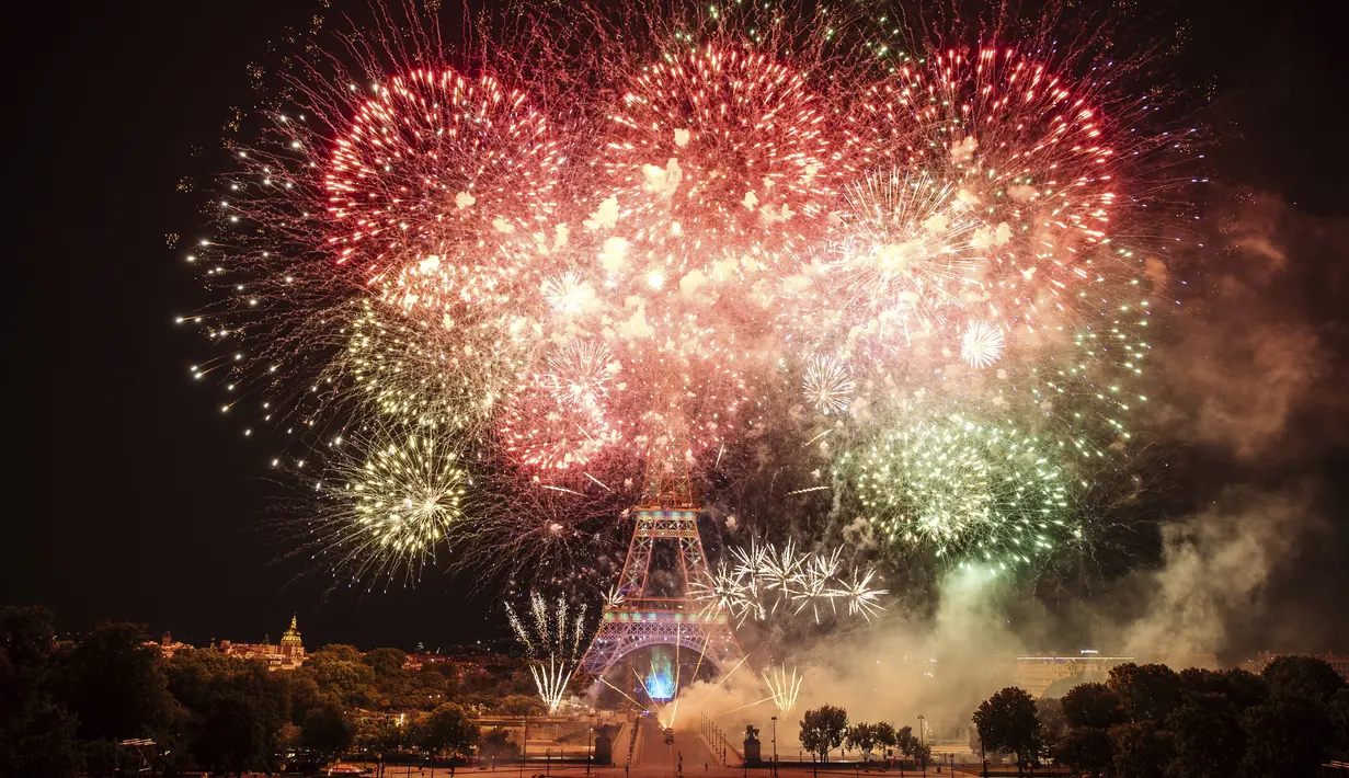 Kembang api menerangi Menara Eiffel selama perayaan Hari Bastille di Paris, Kamis (14/7/2022) malam. Perayaan yang digelar setiap tanggal 14 Juli ini dalam rangka untuk memperingati penyerbuan benteng penjara Bastille pada 14 Juli 1789 silam. (AP Photo/Lewis Joly)