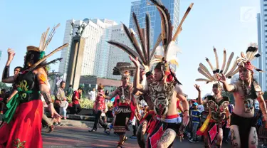 Sejumlah orang mengenakan pakaian adat menari saat pawai festival Budaya Borneo di Car Free Day, Jakarta, Minggu (30/7). Festival tersebut dalam rangka mengenalkan adat dan budaya borneo melalui pakaian dan musiknya. (Liputan6.com/Helmi Afandi)