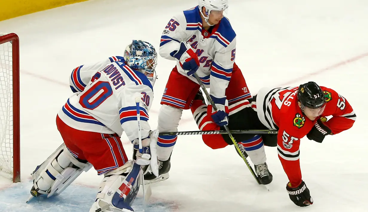 Dua pemain New York Rangers menahan pergerakan pemain Chicago Blackhawks, Tommy Hornels saat pertandingan NHL di Chicago (15/11). Blackhawks unggul 6-3 atas Rangers. (AP/Charles Rex Arbogast)