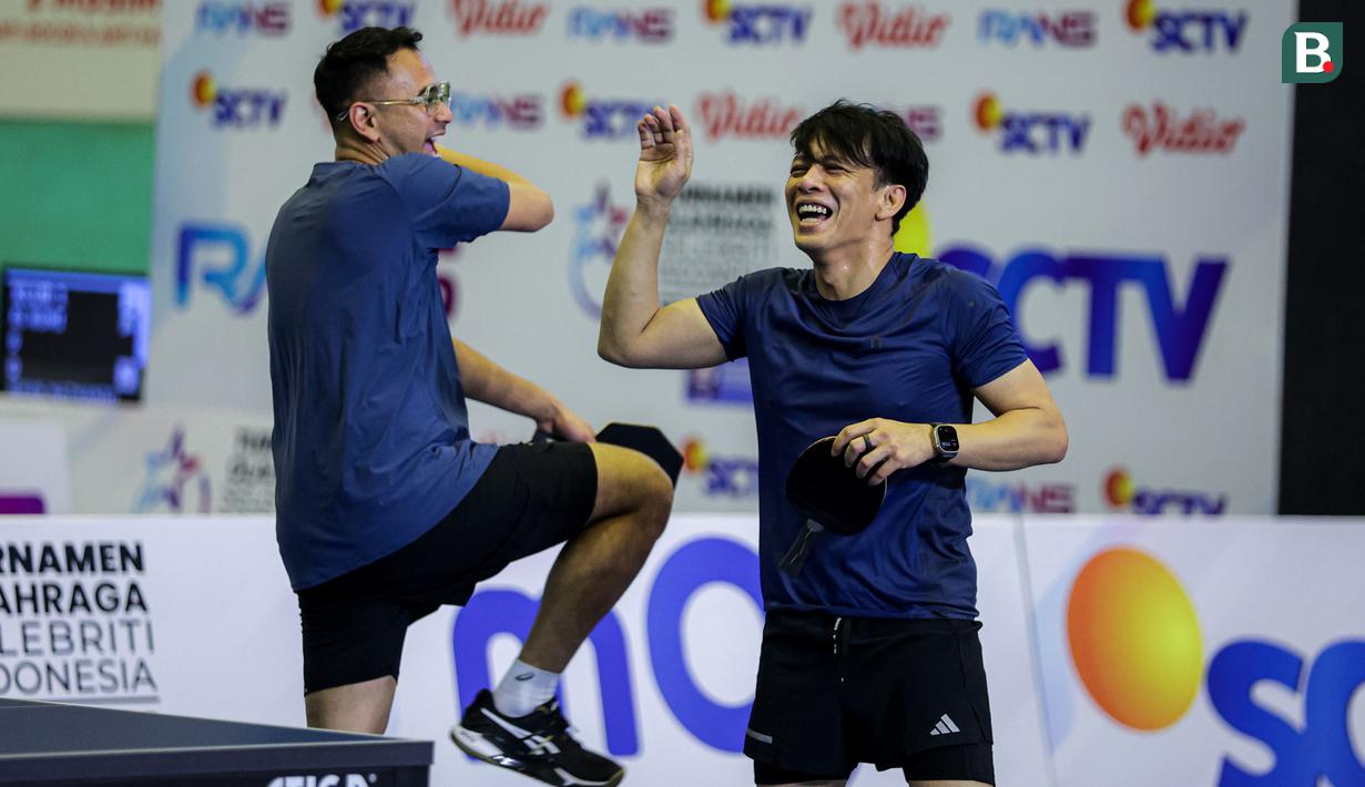 Selebrasi pasangan Raffi Ahmad/Ariel Noah setelah mencetak angka saat menghadapi pasangan Desta/Gading Marten pada laga ganda putra Turnamen Olahraga Selebriti Indonesia (TOSI) season 2 di GOR POPKI Cibubur, Jakarta Timur, Sabtu (13/01/2024). Raffi Ahmad/Ariel Noah menang 3-1 (21-10, 21-14, 17-21 dan 21-13). (Bola.com/Bagaskara Lazuardi)