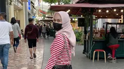 Pakai baju stripe warna merah dipadukan dengan hijab simpel dan celana warna hitam, penampilan sahabat Nabilah Eks JKT48 ini bak anak muda. Tas warna hitam yang senada dengan warna celananya menambah kesan elegan dari penampilan penyanyi yang bergabung dengan JKT48 sejak tahun 2011 ini. (Liputan6.com/IG/@melodylaksani92)