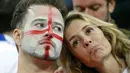 Kesedihan tampak di raut wajah sepasang suporter The Three Lions usai menyaksikan kegagalan Inggris lolos ke fase 16 besar pasca dikalahkan Uruguay 1-2 di Stadion Corinthians, Sao Paulo, Brasil, (20/6/2014). (REUTERS/Laszlo Balogh)