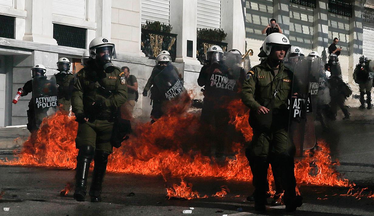 Sejumlah polisi anti huru-hara melawan aksi demonstran yang melemparkan bom api di Athena, Yunani, (12/11/2015). Para Demonstran memprotes langkah-langkah penghematan yang diminta oleh badan pinjaman internasional. (REUTERS/Alkis Konstantinidis)