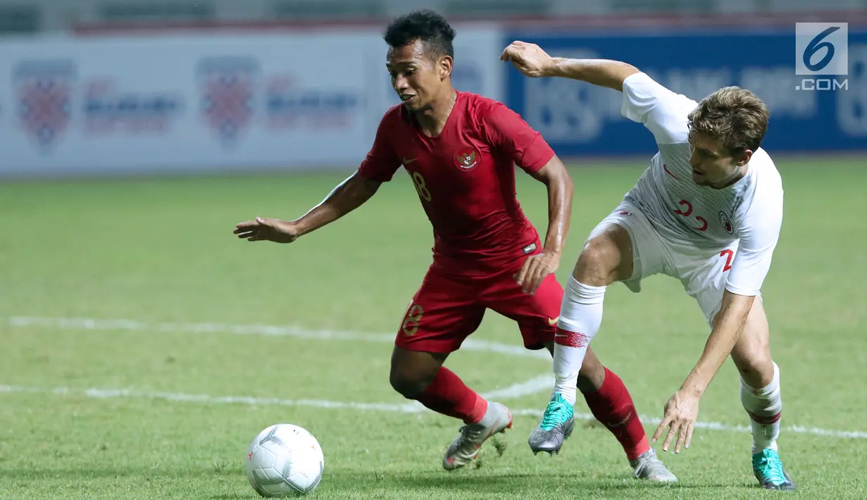Pemain depan Indonesia, Irfan Jaya (kiri) berebut bola dengan pemain Hong Kong, Jaimes Anthony McKee pada laga uji coba internasional di Stadion Wibawa Mukti, Cikarang, Selasa (16/10). Laga berakhir imbang 1-1. (Liputan6.com/Helmi Fithriansyah)