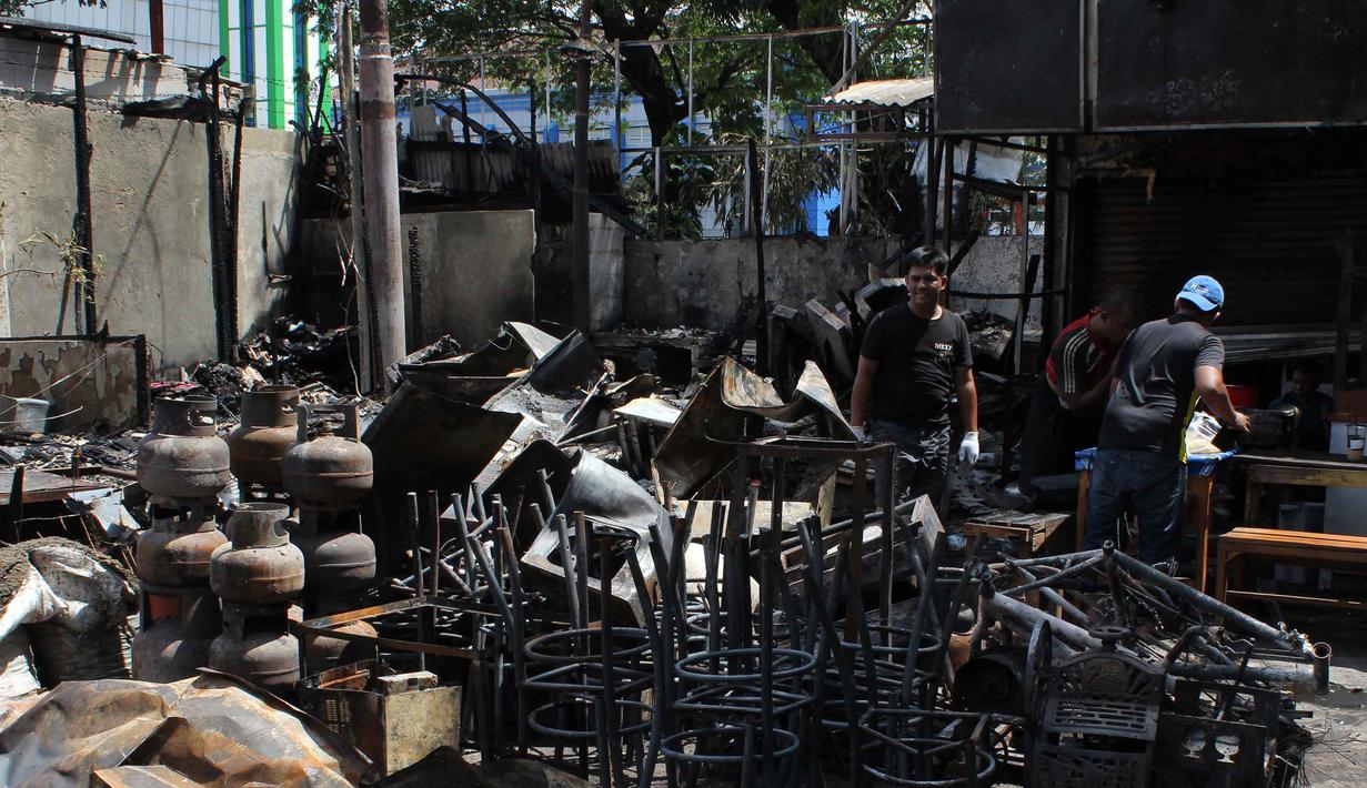 Kasus ini bermula dari masalah utang piutang sepeda motor. Tampak dalam foto, pemilik kios membersihkan puing-puing bangunan usai kebakaran yang melanda deretan kios di kawasan Kalibata, Jakarta Selatan, pada Jumat (12/12/2025). (merdeka.com/magang/Rendi Saputra)