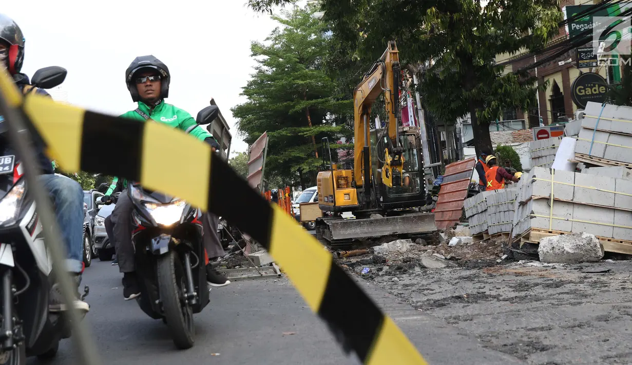 Aktivitas pekerja menyelesaikan proyek revitalisasi trotoar di Jalan Salemba Raya, Jakarta, Jumat (6/9/2019). Proyek revitalisasi trotoar dengan anggaran Rp 75 miliar ini ditargetkan rampung pada Desember mendatang. (Liputan6.com/Helmi Fithriansyah)