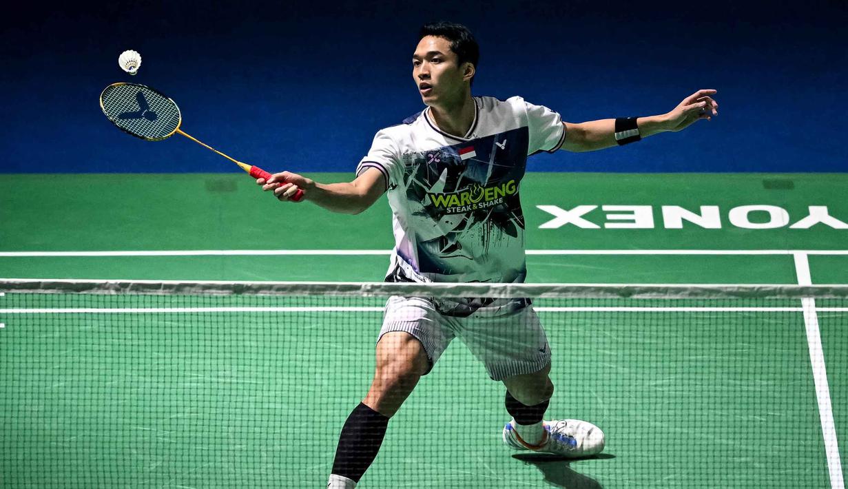 Di final India Open 2026, peraih emas Asian Games 2018 itu kalah dua set langsung dengan skor 10-21 dan 18-21. Tampak dalam foto, tunggal putra Indonesia, Jonatan Christie memukul bola balasan saat pertandingan final tunggal putra melawan Lin Chun-yi (Taiwan) di turnamen bulu tangkis India Open 2026 di Indira Gandhi Indoor Stadium, New Delhi, Minggu (18/1/2026) sore WIB. (Sajjad HUSSAIN/AFP)
