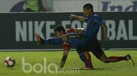 Gelandang Arema FC, Nasir, terjatuh saat berebut bola dengan bek Persib Bandung, Henhen Herdiana, pada laga Liga 1 di Stadion GBLA Bandung, Jawa Barat, Sabtu (15/4/2017). (Bola.com/M Iqbal Ichsan)