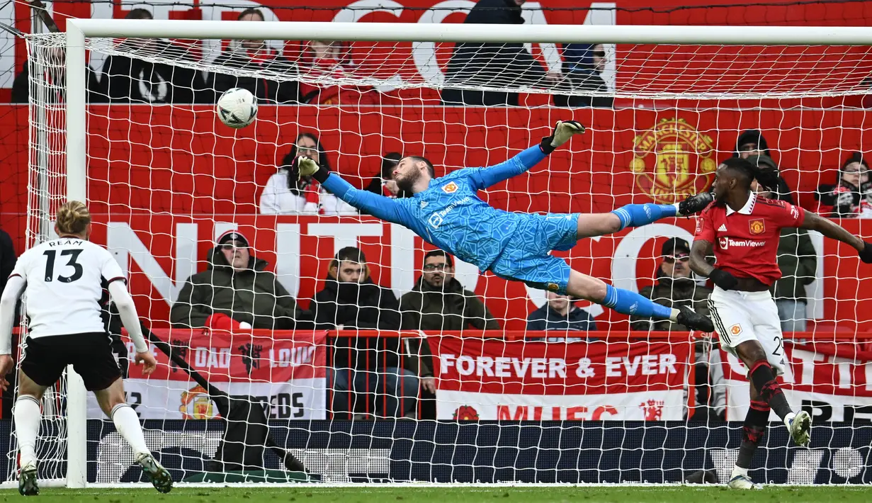 Penjaga gawang Manchester United, David De Gea (tengah), berhasil menghalau bola dari sundulan pemain Fulham dalam babak perempat final Piala FA 2022/2023, Minggu (19/3/2023) malam WIB. Berkat hasil ini, Manchester United pun berhak melenggang ke babak semifinal untuk menghadapi Brighton di Wembley. (AFP/Paul Ellis)