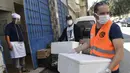 Relawan dari asosiasi Nass el-Khir mendistribusikan makanan kepada mereka yang membutuhkan selama bulan suci Ramadan di Aljir, Aljazair, Senin (18/5/2020). (RYAD KRAMDI/AFP)