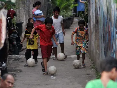 Sejumlah anak bermain bola di gang kecil kawasan Benhil, Jakarta, Rabu (10/6/2015). Anak-anak ini memanfaatkan gang kecil untuk bermain bola dikarenakan kurangnya sarana bermain khususnya lapangan bola di Jakarta. (Liputan6.com/Johan Tallo)