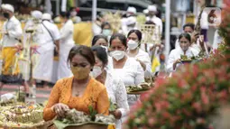 Umat Hindu membawa sesaji saat mengikuti upacara Tawur Agung Kesanga di Pura Amerta Jati, Cinere, Depok, Rabu (2/3/2022).  Upacara Tawur Agung Kesanga itu sebagai penyucian diri guna memperingati Hari Raya Nyepi Tahun Baru Saka 1944. (Liputan6.com/Faizal Fanani)