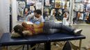 Seorang seniman terlihat serius menato seorang perempuan dibagian samping dadanya saat Festival Internasional Tattoo Week Rio 2016 ketiga di Rio de Janeiro, Brasil, (22/1/2016). (REUTERS/Pilar Olivares)