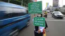 Petugas Badan Pengelola Transportasi Jabodetabek (BPTJ) berdiri sambil membawa papan imbauan saat uji coba sistem kanalisasi 2-1 Jalur Puncak di kawasan Gadog, Bogor, Jawa Barat, Minggu (27/10/2019). (merdeka.com/Arie Basuki)