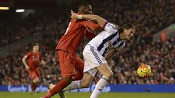 Bek West Bromwich, Jonas Olsson, menghadang pergerakan penyerang Liverpool, Christian Benteke, pada laga Liga Premier Inggris di Stadion Anfield, Inggris, Minggu (13/12/2015). (AFP/Oli Scarff)