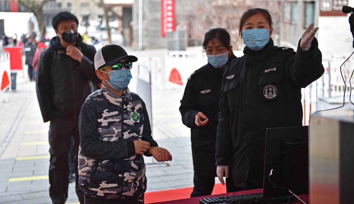 Petugas memeriksa suhu tubuh wisatawan di pintu masuk Tembok Besar bagian Badaling di Beijing, 24 Maret 2020. Bagian dari Tembok Besar yang terkenal di Beijing itu telah dibuka kembali sebagian pada Selasa (24/3), setelah ditutup selama hampir dua bulan akibat corona COVID-19. (Xinhua/Chen Zhonghao)