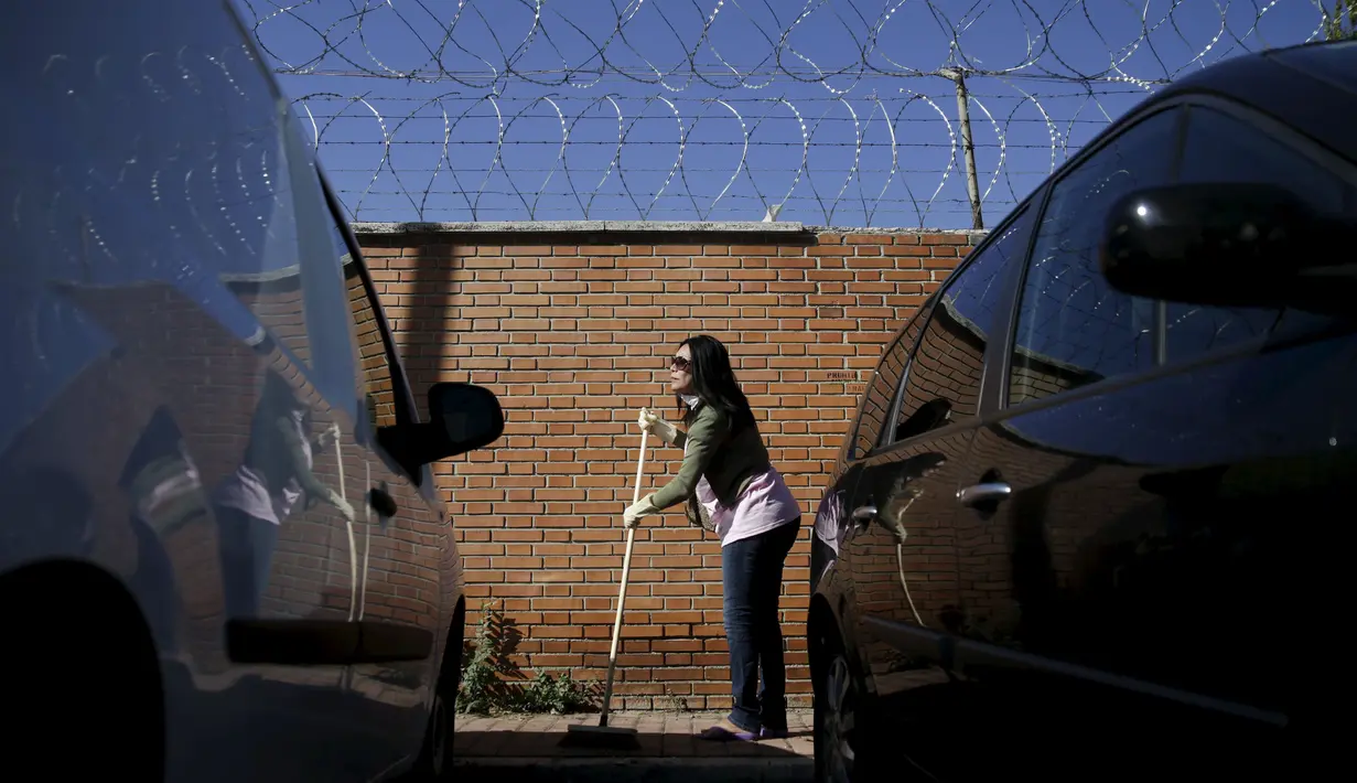 Seorang wanita pekerja seks menyapu jalanan kota madrid, Spanyol , Rabu  (14/10/2015).   Kegiatan ini mereka lakukan untuk mengecam perlakukan terhadap profesi mereka di masyrakat. (REUTERS /Andrea Comas)