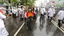 Seorang petugas kebersihan DKI Jakarta membawa kantung plastik untuk membersihkan sampah  usai aksi damai 2 Desember di kawasan Jalan MH Thamrin, Jakarta, Jumat (2/12). (Liputan6.com/Ferbian Pradolo)