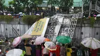 Warga menonton Jembatan Penyeberangan Orang (JPO) yang roboh akibat hujan deras dan angin kencang di Jalan Raya Pasar Minggu, Jakarta Selatan, Sabtu (24/09). Petugas masih memotong bagian JPO tersebut. (Liputan6.com/Immanuel Antonius)