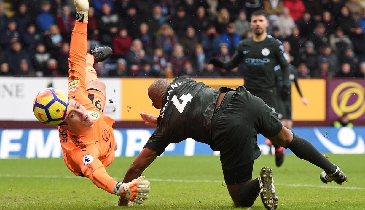 Aksi bek Manchester City, Vincent Kompany (kanan) berebut bola dengan kiper Burnley, Nick Pope pada lanjutan Premier League di Turf Moor Stadium, Burnley, (3/2/2018). Burnley tahan Manchester City 1-1. (AFP/Oli Scarff)
