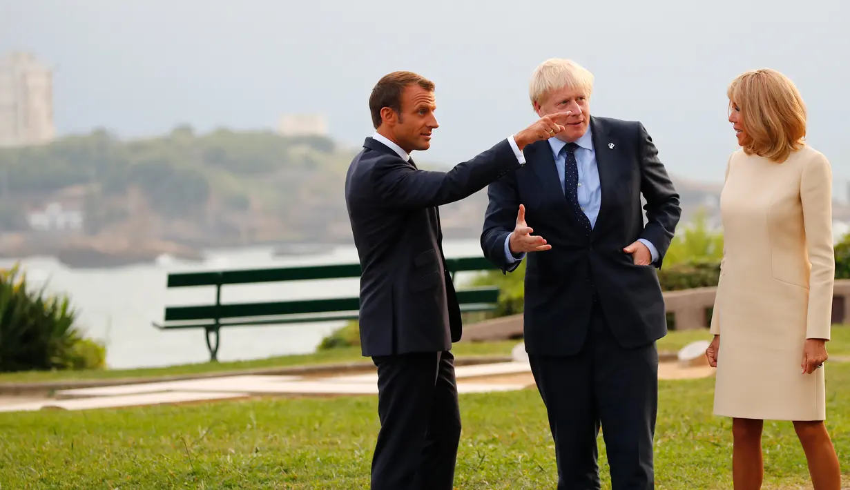 Presiden Prancis Emmanuel Macron (kiri) dan istrinya Brigitte Macron (kanan) menyambut kedatangan Perdana Menteri Inggris Boris Johnson (tengah) di KTT G7, Biarritz, Prancis, Sabtu (24/8/2019). (AP Photo/Francois Mori, Pool)