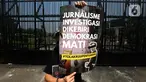 Salah satu pewarta membentangkan poster saat aksi penolakan terhadap revisi Rancangan Undang-Undang (RUU) Penyiaran di depan Gedung Kompleks Parlemen (MPR/DPR/DPD), Jakarta, Senin (27/5/2024). (Liputan6.com/Helmi Fithriansyah)