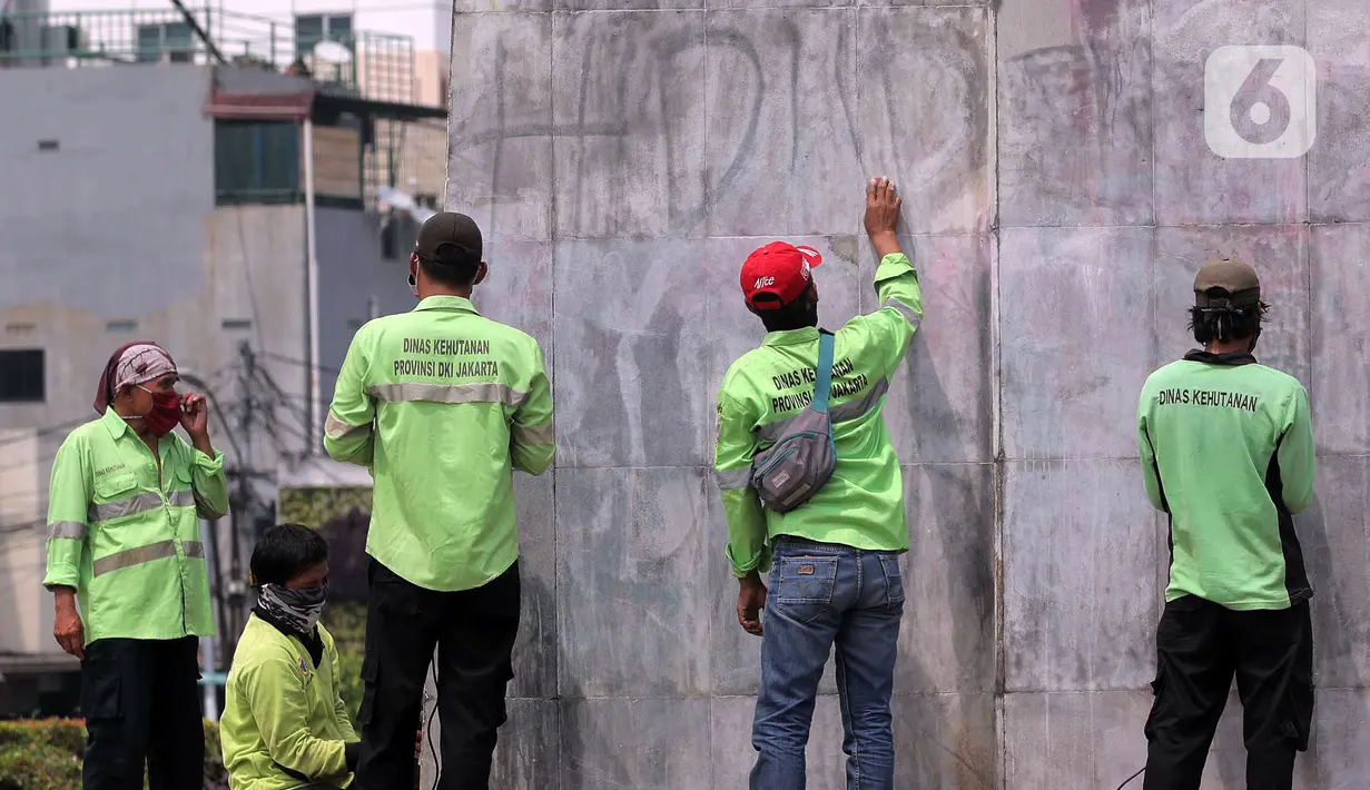 Petugas PPSU DKI Jakarta membersihkan coretan di kawasan Kebon Sirih, Jakarta Pusat, Sabtu (10/10/2020). Dinas kebersihan dari PPSU dan Satpel DLH melakukan penghapusan coretan di fasilitas umum oleh pengunjuk rasa saat demonstrasi tolak Omnibus Law UU Cipta Kerja. (Liputan6.com/Johan Tallo)