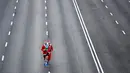 Pelari mengenakan kostum Sinterklas ambil bagian dalam Santa Claus Run di Madrid, Spanyol, Minggu (9/12). Ribuan orang berjalan dan berlari dalam perlombaan Santa tahunan melintasi jalan-jalan ibu kota Spanyol. (Gabriel BOUYS / AFP)