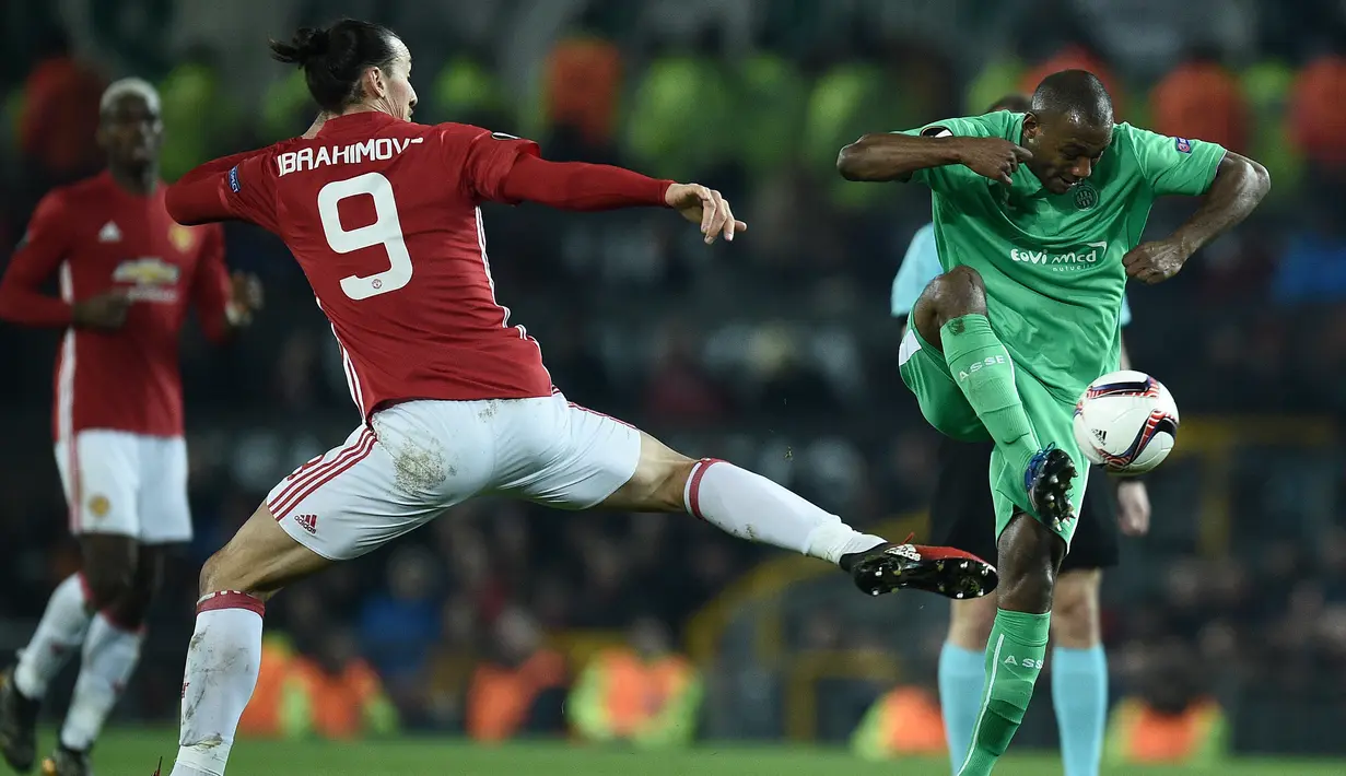 Penyerang Manchester United, Zlatan Ibrahimovic berusaha merebut bola dari bek Saint-Etienne Kevin Theophile-Catherine saat bertanding di Liga Eropa di Olad Trafford, Inggris, (16/2). MU menang telak atas Saint-Etienne 3-0. (AFP Photo / Oli Scarff)