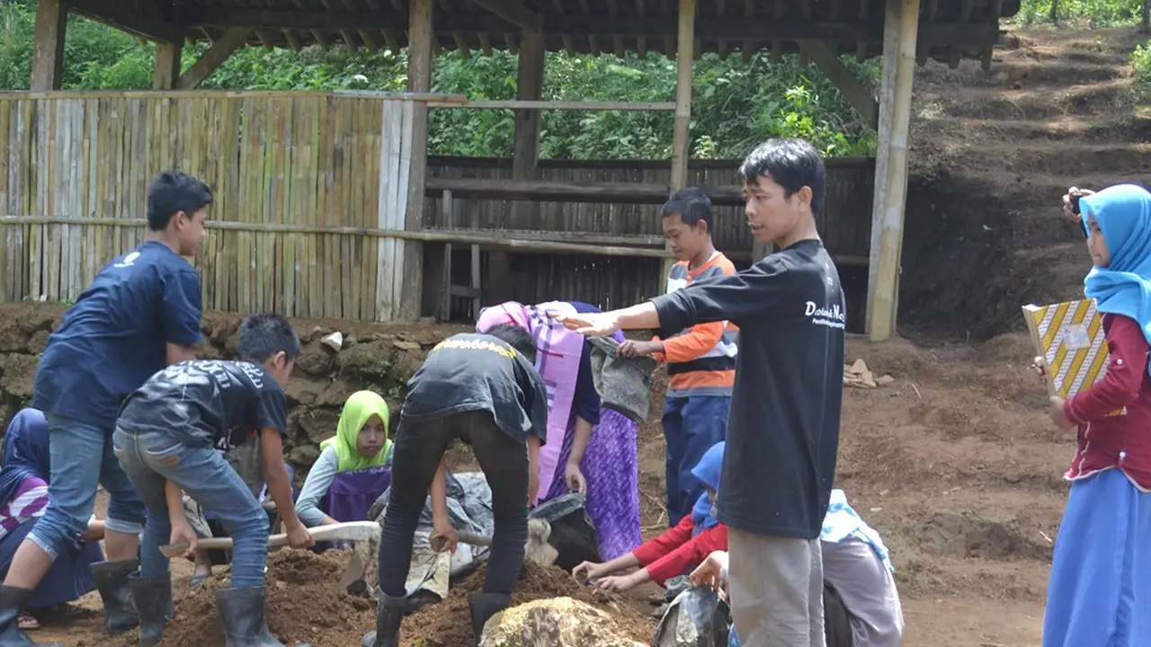 Isrodin mendampingi siswa MTs Pakis, Cilongok, Banyumas untuk membuat media pendederan bibit tanaman. (Foto: Liputan6.com/Muhamad Ridlo)