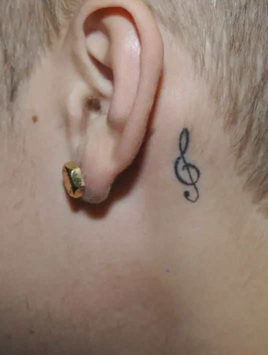 Tato di balik telinga kiri Justin Bieber berbentuk simbol stradivarius. (Bintang/EPA)