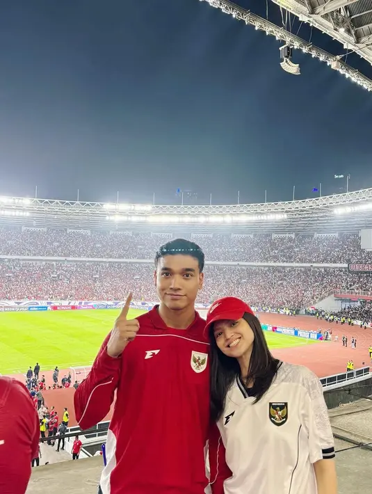 Maudy Effrosina memilih jersey Timnas warna putih, sementara Fadly Faisal tampil dengan jersey lengan panjang merah yang ia padukan dengan celana jeans. Kombinasi simpel namun tetap stylish ini menambah daya tarik keduanya di tengah euforia pertandingan. [@fadlyfsl].