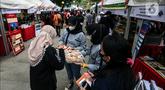 Warga memilih makanan saat mengunjungi stan UMKM Bazaar Kuliner di kawasan Jakarta, Minggu (26/6/2022). Bazar ini diselenggarakan dalam rangkaian perayaaan HUT ke-495 DKI Jakarta. (Liputan6.com/Johan Tallo)