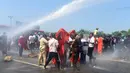 Polisi Sri Lanka menembakan water canon untuk membubarkan aktivis dan biksu saat aksi protes di kota pelabuhan selatan Hambantota, Sri Lanka (7/1). (AFP/Ishara S. Kodikara)