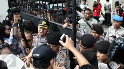 Petugas kepolisian berjaga di pintu masuk Pengadilan Negeri (PN) Jakarta Utara, Selasa (13/12). Ratusan orang membludak berebut masuk ke ruang sidang perdana Basuki Tjahaja Purnama (Ahok) yang berkapasitas maksimal 80 orang. (Liputan6.com/Faizal Fanani)