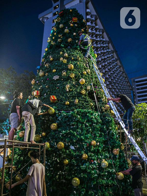 Pekerja menyelesaikan pembuatan Pohon Natal di Thamrin 10, Jakarta, Selasa (22/12/2020). Pohon Natal akan dipasang pada 23 Desember hingga 1 Januari mendatang. (Liputan6.com/Faizal Fanani)
