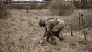Seorang anggota regu penjinak bom bekerja di ladang ranjau dekat Brovary, timur laut Kiev, di tengah invasi militer Rusia pada 14 April 202. Rusia sudah menarik tentara mereka dari Kiev dan mengalihkan sebagian besar fokus perangnya ke wilayah Ukraina timur pada akhir Maret. (FADEL SENNA/AFP)